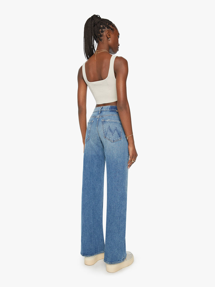 Back view of a woman super wide-leg jeans with a high rise and a long 32-inch inseam in a mid blue wash.