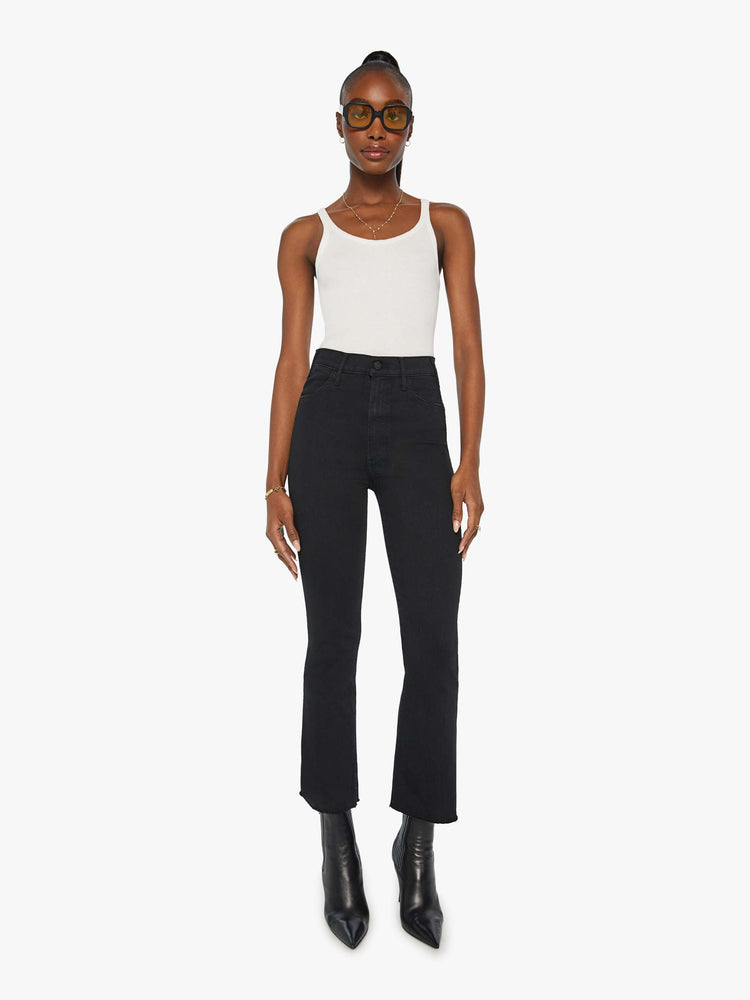 Front view of a womens black jean featuring a high rise, a flare leg, and an ankle length raw hem.