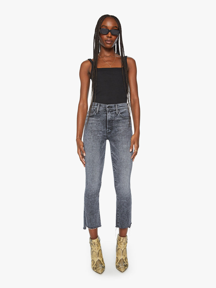 Front view women's high waisted mineral wash black straight leg denim with step fray hem detail.