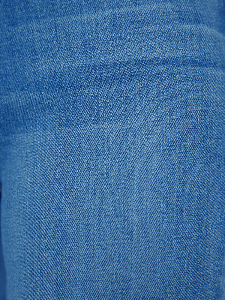 Swatch view of a woman high-rise flare with a button fly and a clean ankle-length hem in a mid-blue wash.
