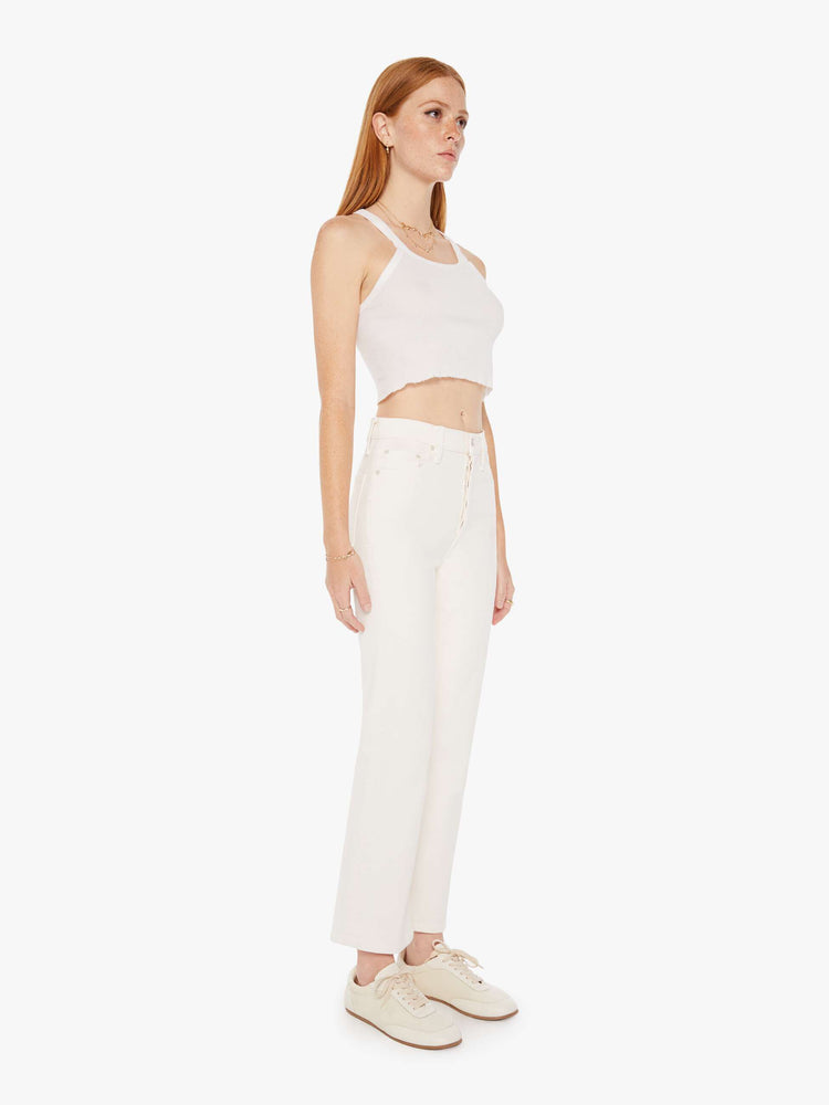Front view of an off white color jean featuring a high rise and an ankle length flare with clean hem.