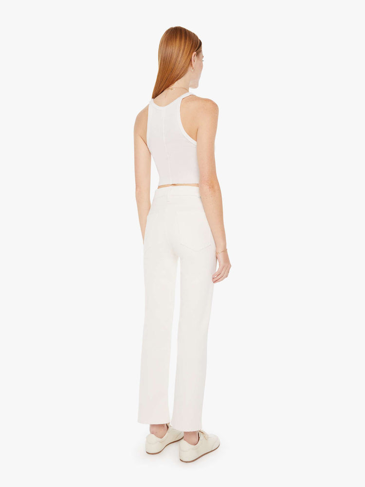 Back view of an off white color jean featuring a high rise and an ankle length flare with clean hem.
