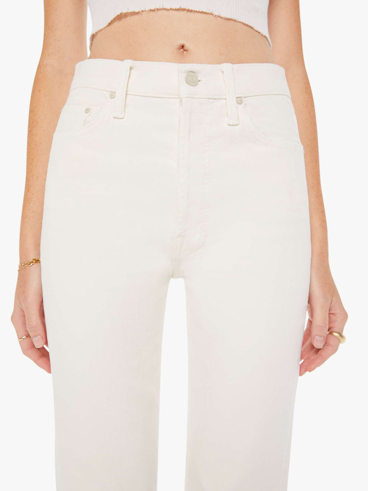 Front close up view of an off white color jean featuring a high rise.