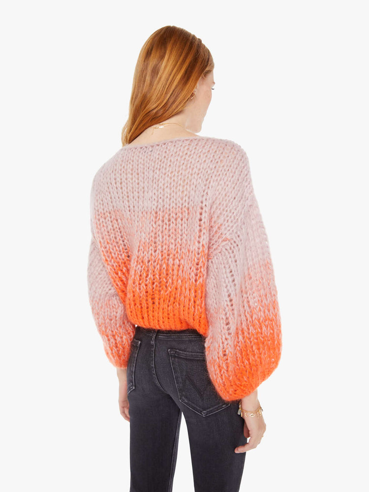 Back view women's long sleeve sweater in colors orange and pink.