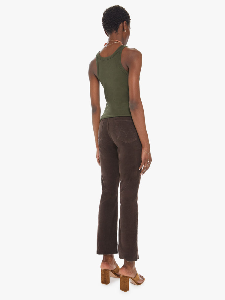 Back view of a womens brown corduroy pant featuring a high rise and a raw cut flare hem.