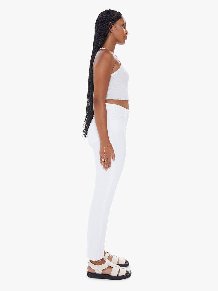 Side view of a womens white wash jean featuring a high rise, flare leg, and a frayed hem.