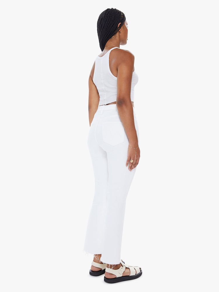 Back view of a womens white wash jean featuring a high rise, flare leg, and a frayed hem.