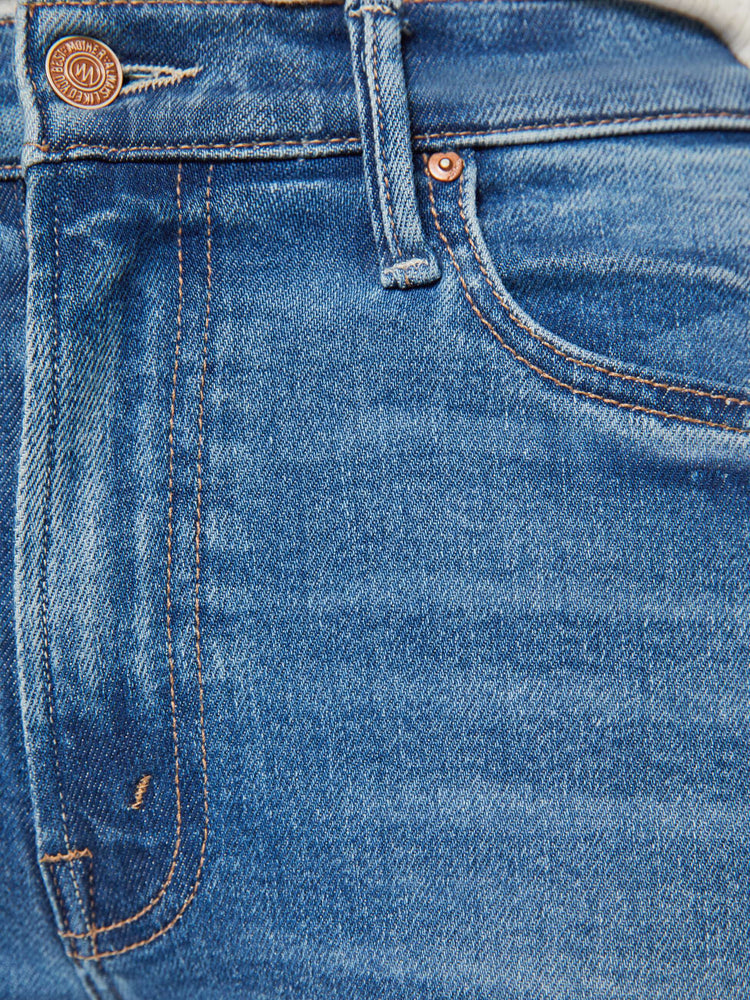 Swatch Close up view of a woman in a mid blue high-rise straight leg jean with a 32-inch inseam and a clean hem.