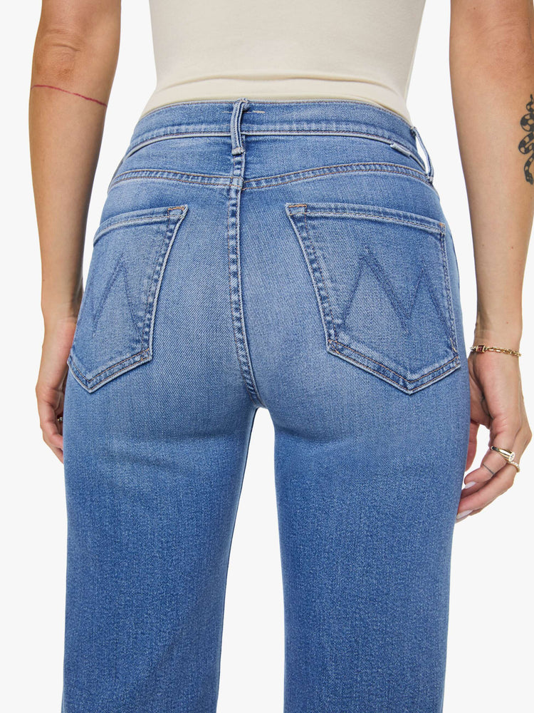 Close up view of a woman in mid blue high-rise straight leg jean with a 32-inch inseam and a clean hem.