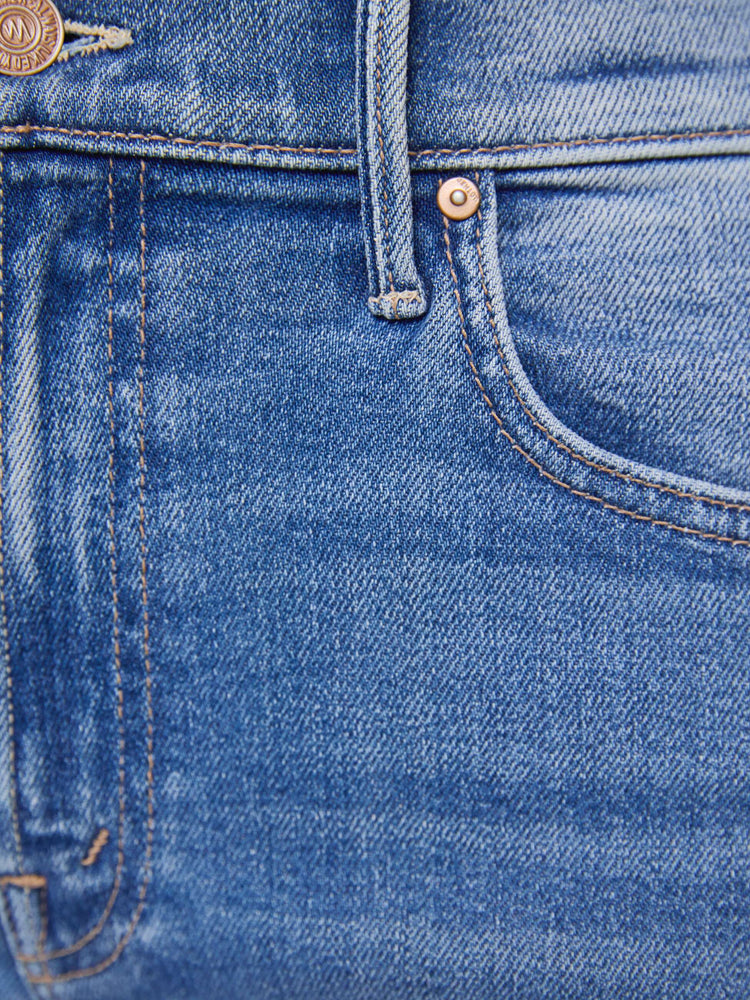 Swatch view of a woman in mid blue high-rise straight leg jean with a 32-inch inseam and a clean hem.