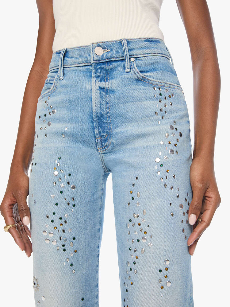 Close up view of a woman in a light blue with crystal embellishments high-rise straight-leg jean with a zip fly, 32-inch inseam and a clean hem. 