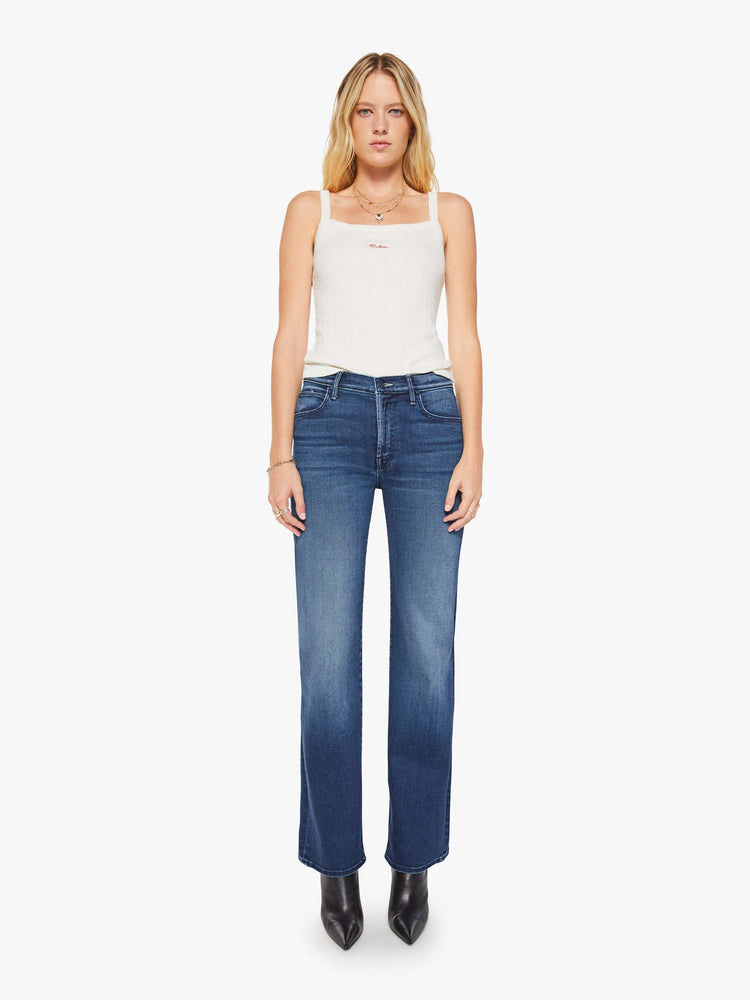 Front view of a woman in a dark blue high-rise straight leg jean with a 32-inch inseam and a clean hem.
