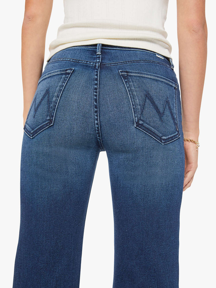 Close up view of a woman in a dark blue high-rise straight leg jean with a 32-inch inseam and a clean hem.