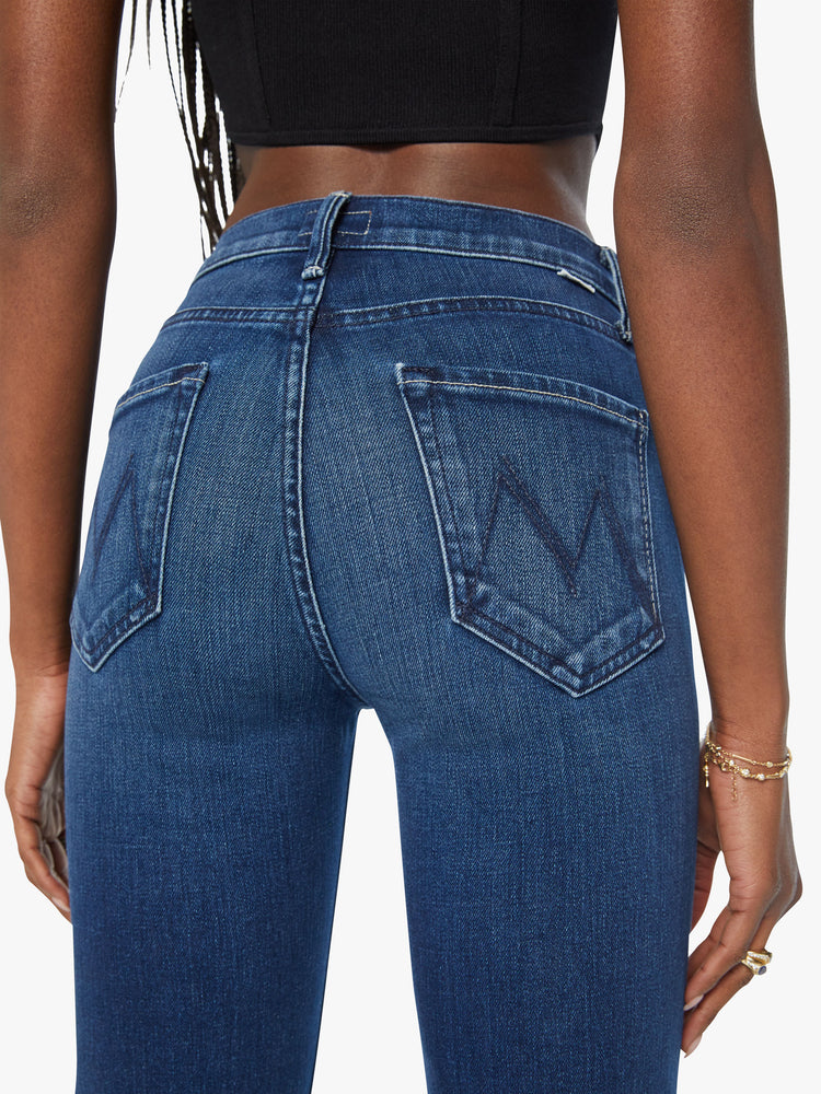 Back close up view of a woman dark blue high-waisted bootcut with a 32-inch inseam and a clean hem.