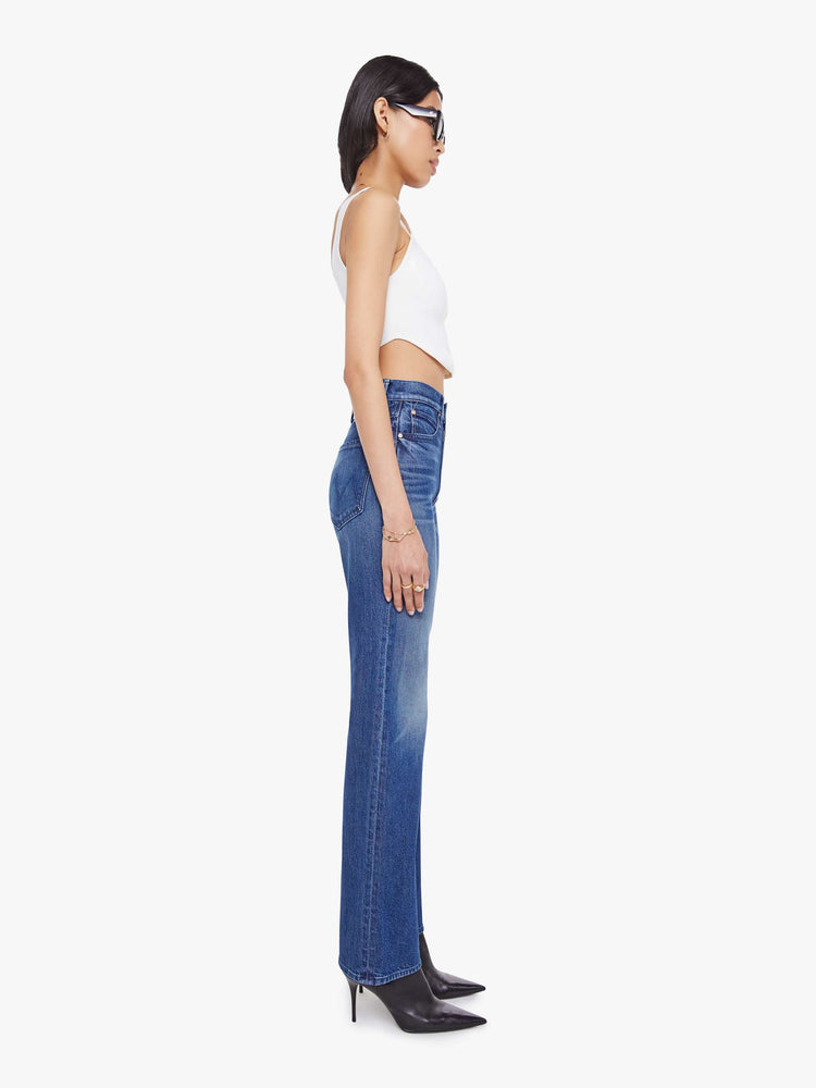 Side view of a woman in a high-rise straight leg jean with a zip fly, 32-inch inseam and a clean hem. 