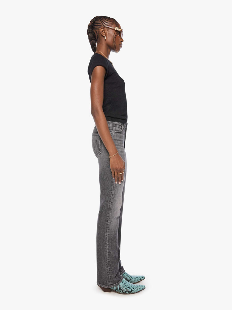 Side view of a woman in a washed black high-rise straight-leg jean with a zip fly, 32-inch inseam and a clean hem.