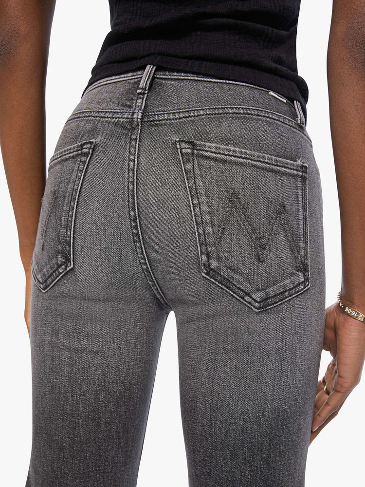 Close up view of a woman in a washed black high-rise straight-leg jean with a zip fly, 32-inch inseam and a clean hem.