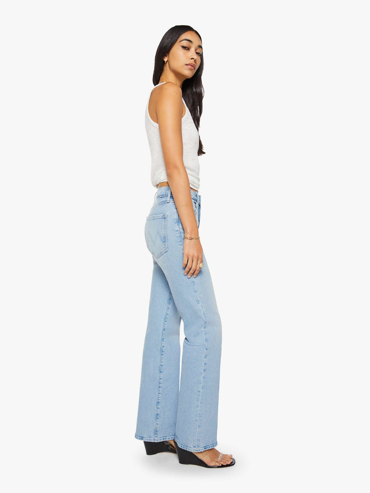 Side view of a woman in a light blue high-rise straight-leg jean with a zip fly, 32-inch inseam and a clean hem.