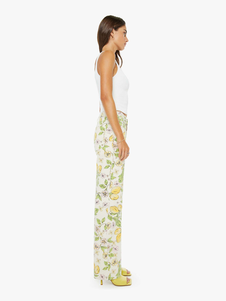 Side view of a woman in an off white with pastel blossom print high-rise straight leg jean with a zip fly, 32-inch inseam and a clean hem. 