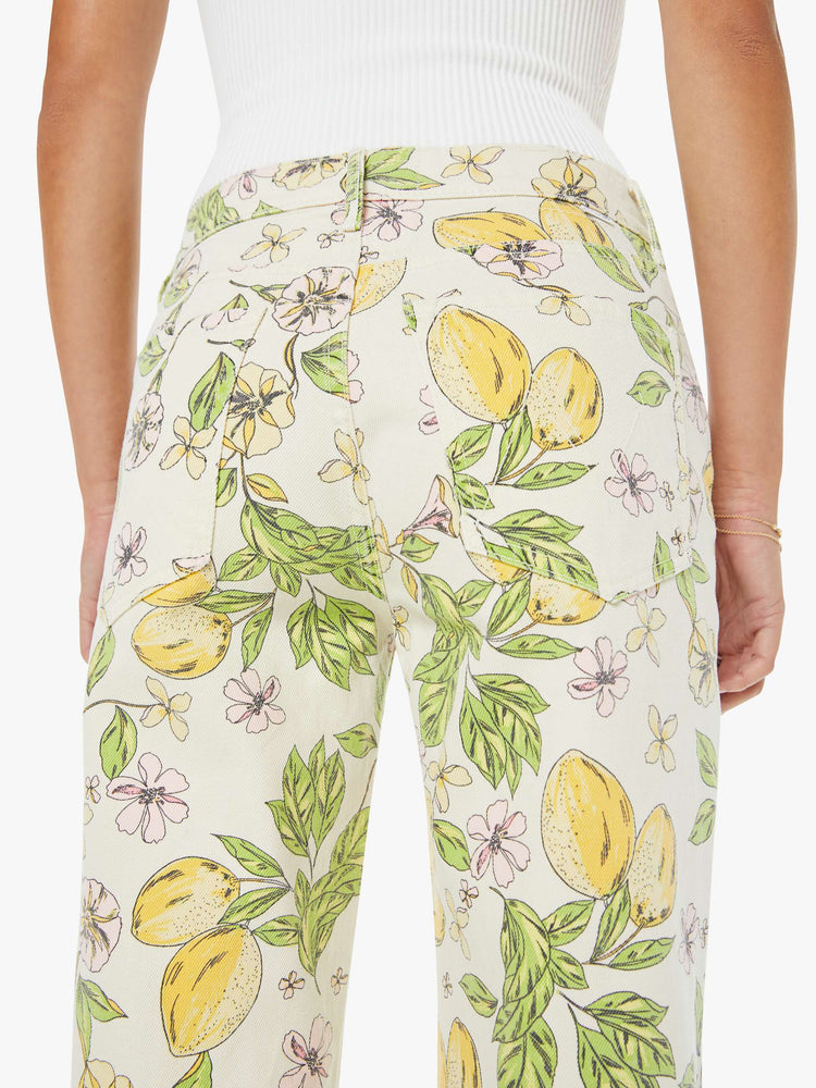 Back close up view of a woman in an off white with pastel blossom print high-rise straight leg jean with a zip fly, 32-inch inseam and a clean hem. 