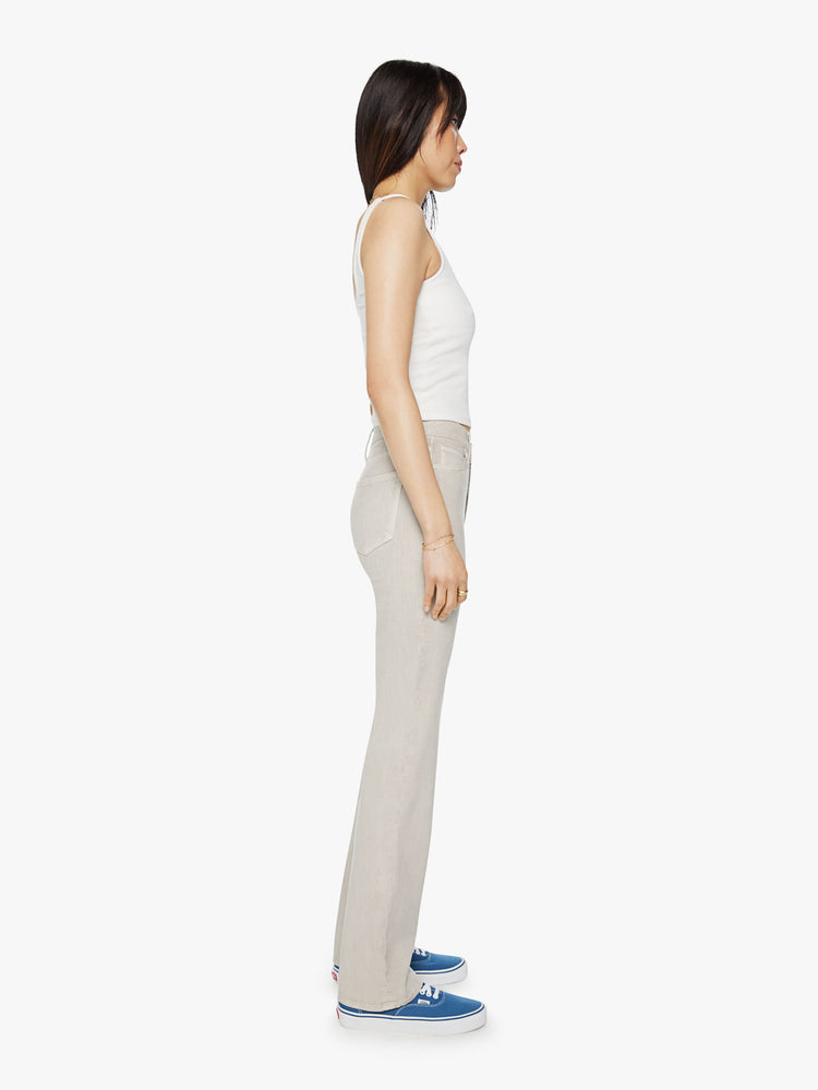 Side view of a woman off white pant with a high-rise, straight-leg with a 32-inch inseam and a clean hem.