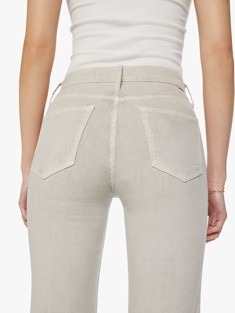 Close up view of a woman off white pant with a high-rise, straight-leg with a 32-inch inseam and a clean hem.
