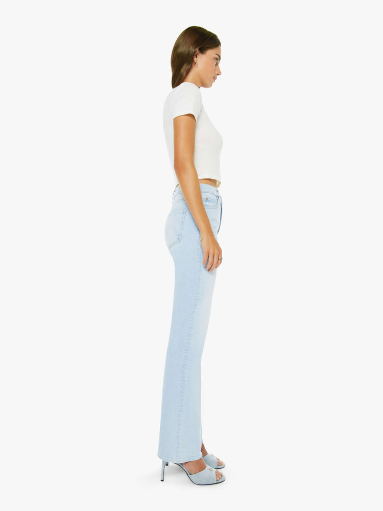Side view of a woman in a light blue high-rise straight leg jean with a zip fly, 32-inch inseam and a clean hem.