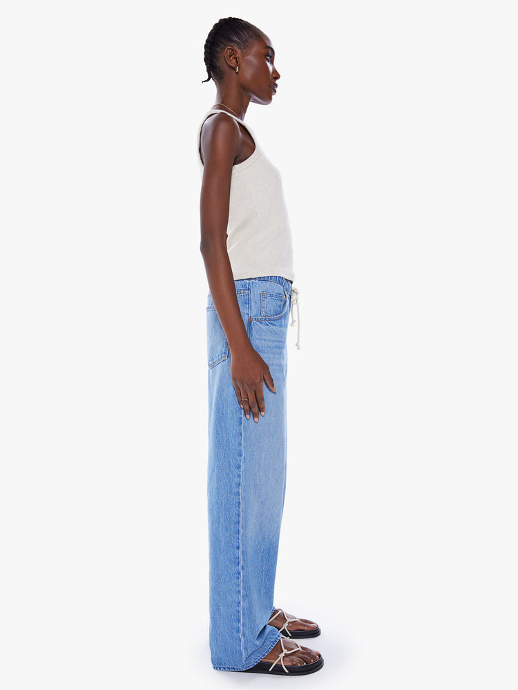Side view of a woman wide-leg jean feature a drawstring waist, zip fly, slit pockets and a long 30-inch inseam in a mid-blue wash.