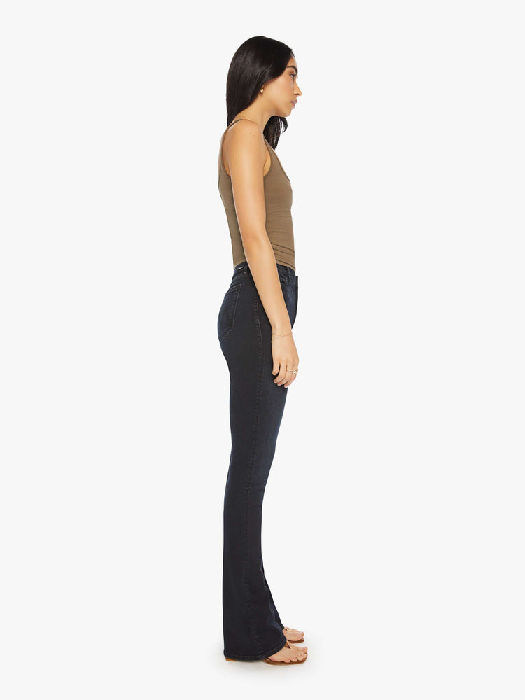Side view of a woman classic mid-rise bootcut with a long 34-inch inseam and a clean hem in a dark blue wash.