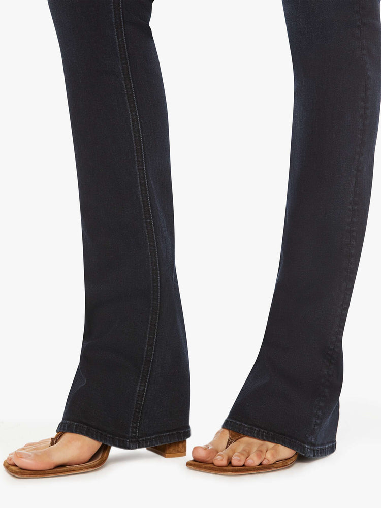 Hem view of a woman classic mid-rise bootcut with a long 34-inch inseam and a clean hem in a dark blue wash.