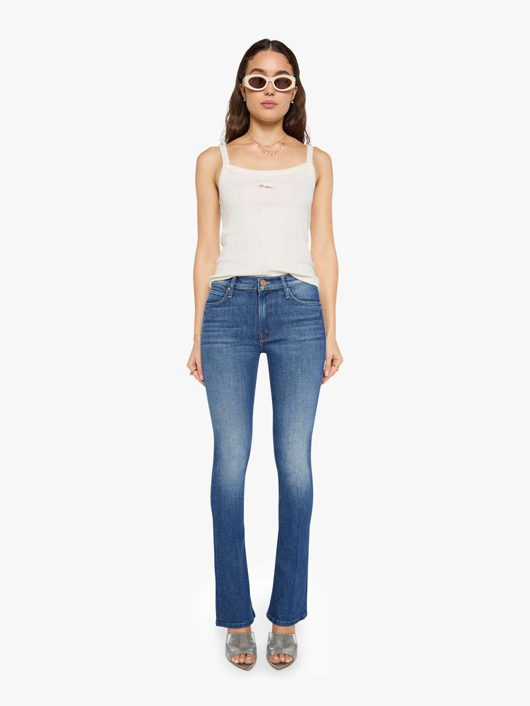 Front view of a woman in mid blue skinny flare with a mid rise, zip fly and a long 34-inch inseam with a clean hem.