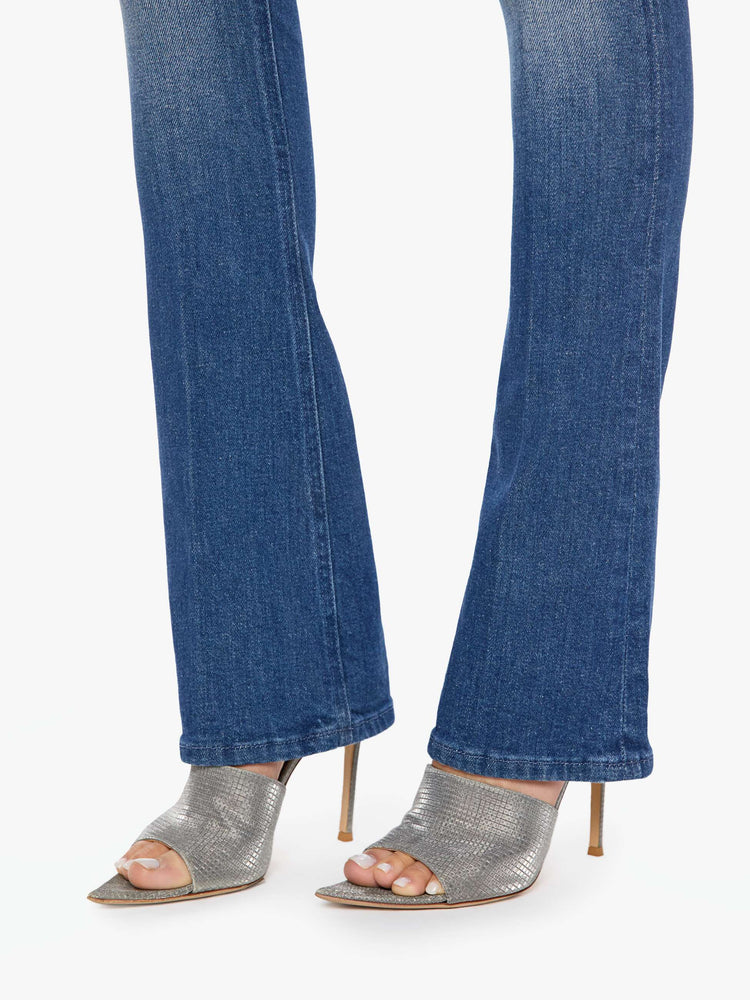 Close up view of a woman in mid blue skinny flare with a mid rise, zip fly and a long 34-inch inseam with a clean hem.