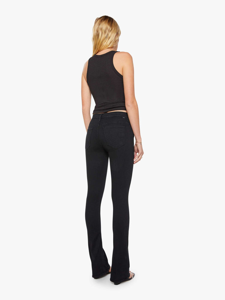 Back view of a womens black wash jean featuring a mid rise and skinny flare.