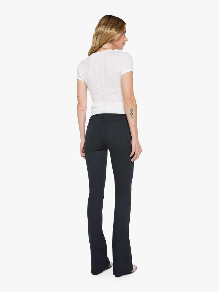 Back view of a womens black wash jean featuring a mid rise and skinny flare.