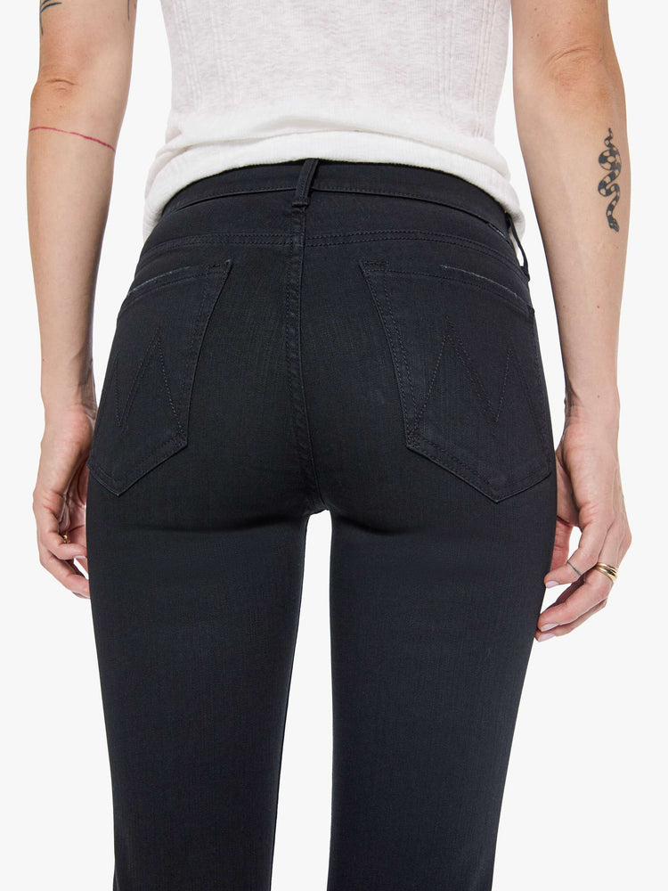 Front close up view of a womens black wash jean featuring a mid rise and skinny flare.