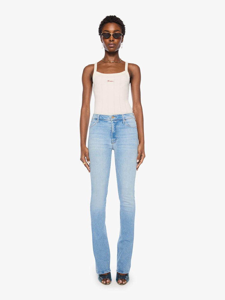Front view of a woman in a light blue classic skinny flare with a mid rise, zip fly and a long 34-inch inseam with a clean hem.