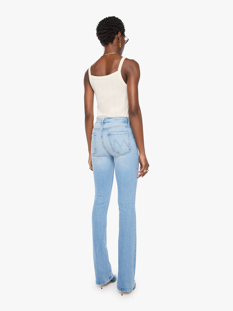 Back view of a woman in a light blue classic skinny flare with a mid rise, zip fly and a long 34-inch inseam with a clean hem.