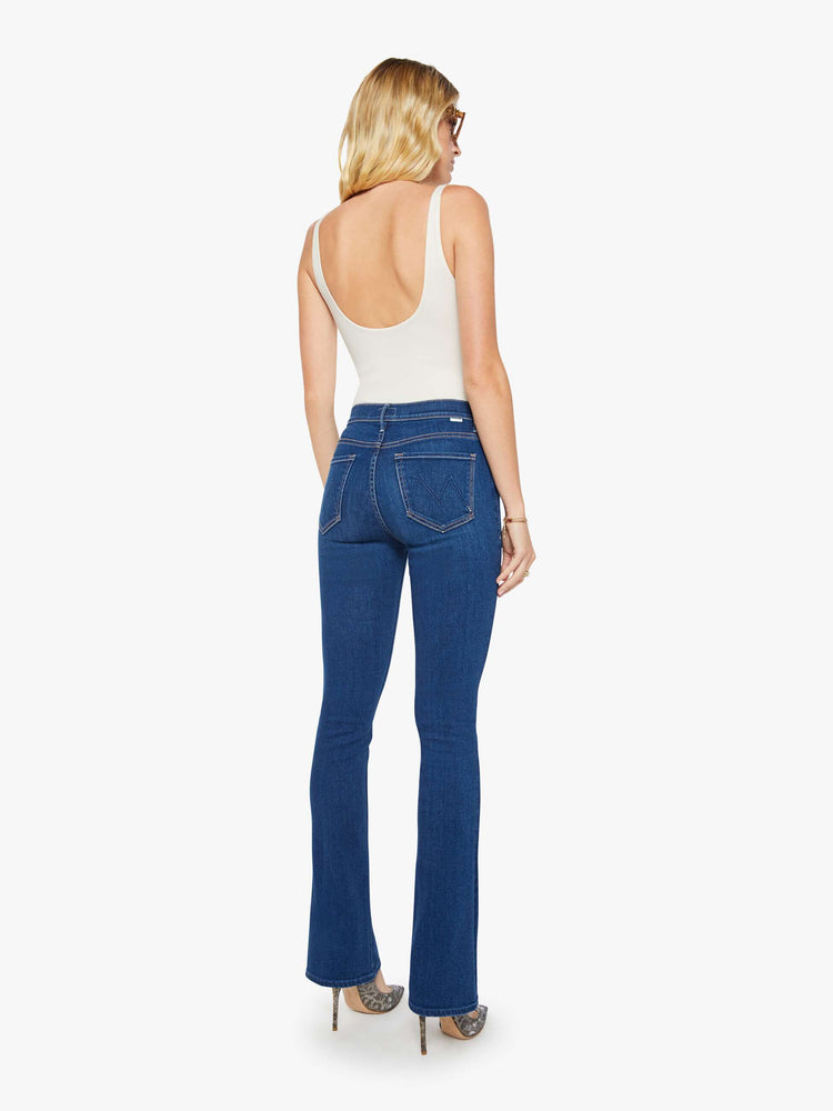 Back view of a woman in a skinny flare with a mid rise, zip fly and a long 34-inch inseam with a clean hem.