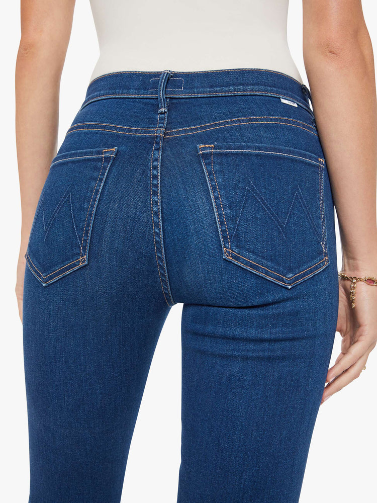 Close up view of a woman in a skinny flare with a mid rise, zip fly and a long 34-inch inseam with a clean hem.
