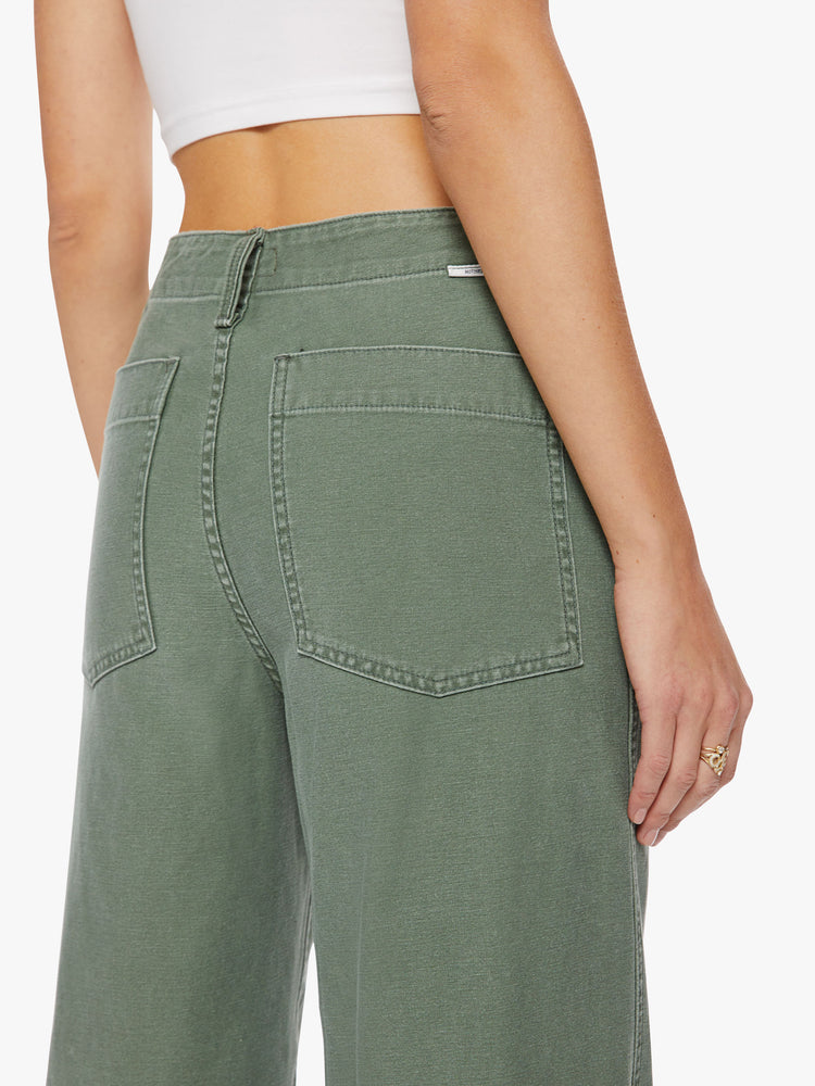 Back close up view a woman army green super high waisted pants with a loose straight leg, side slit pockets, a long 33.5-inch inseam and a frayed hem.