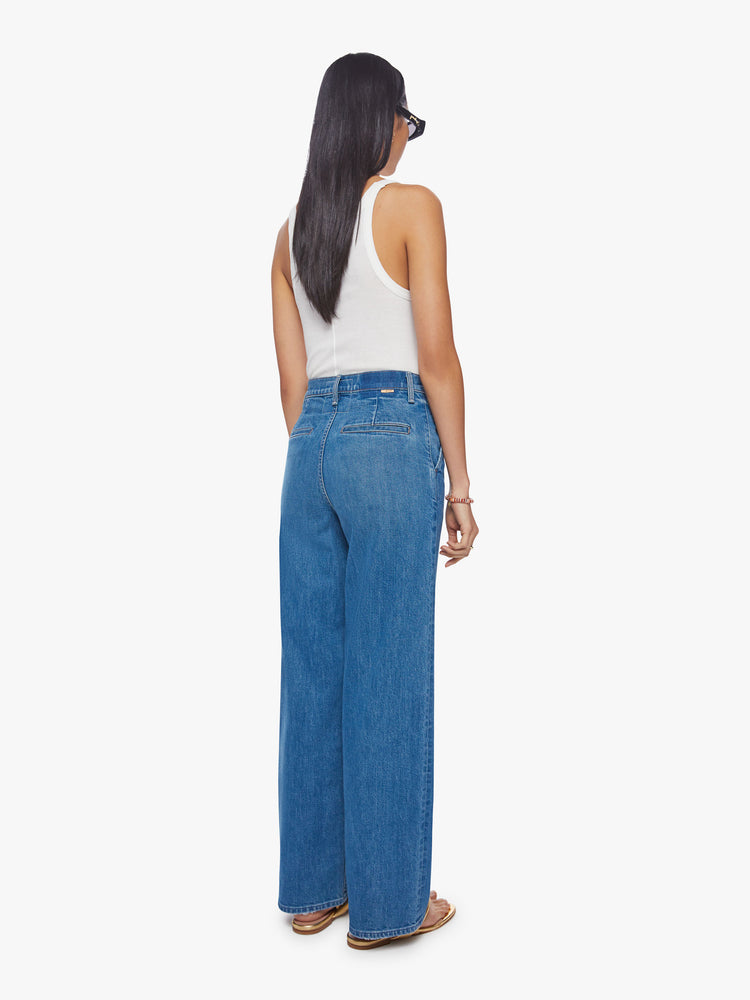 Back view of a woman super high-rise jeans with a loose wide leg, button fly, slit pockets and a 31-inch inseam with a clean hem in med-blue wash.