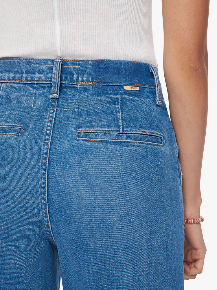 Back close up view of a woman super high-rise jeans with a loose wide leg, button fly, slit pockets and a 31-inch inseam with a clean hem in med-blue wash.