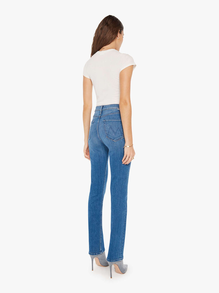 Back view of a woman mid blue high-waisted straight leg has a 31-inch inseam and a clean hem.