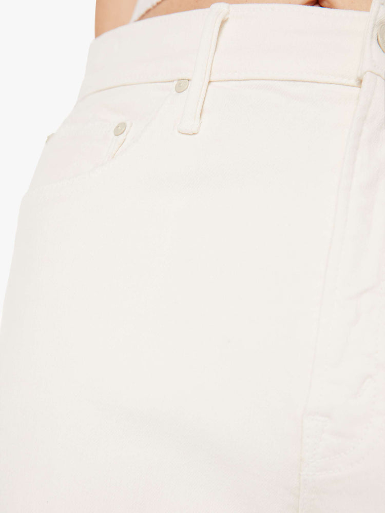 A close up swatch detail view of an off white jean featuring matching tonal hardware and stitching.