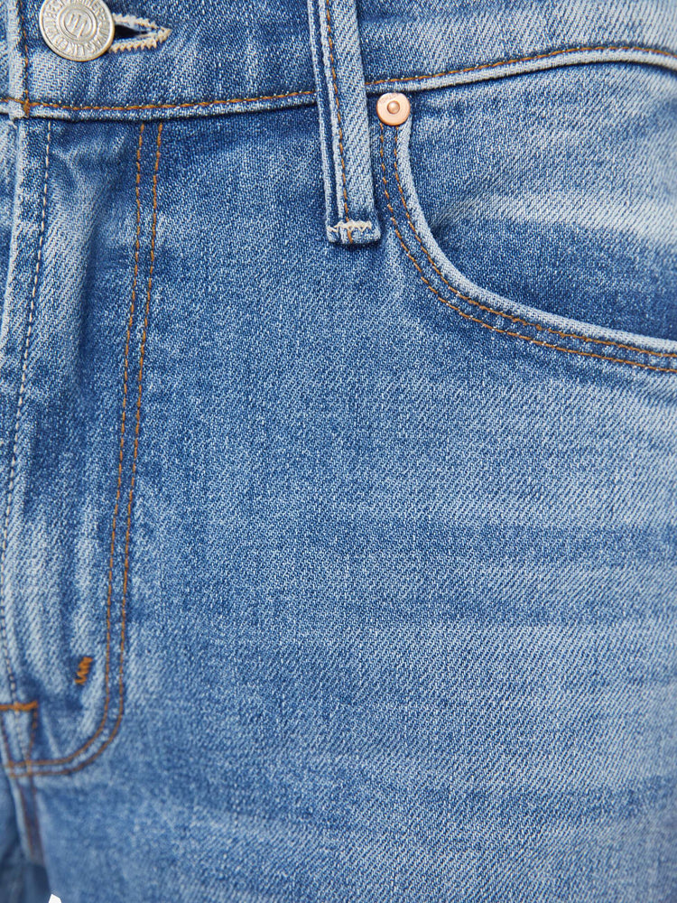 Swatch view of a woman in a vintage blue high-rise flare with a zip fly, long 34-inch inseam and a frayed hem.