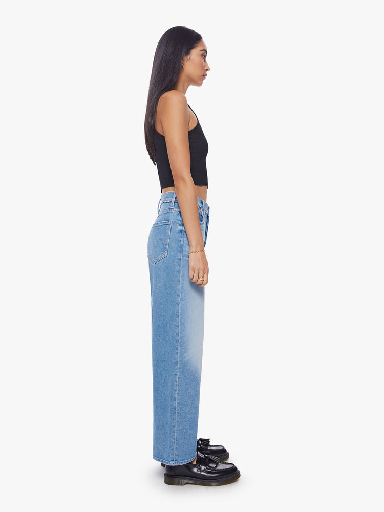 Side view of a super high-rise jeans with a loose wide leg, button fly and a clean hem in a mid-blue wash.