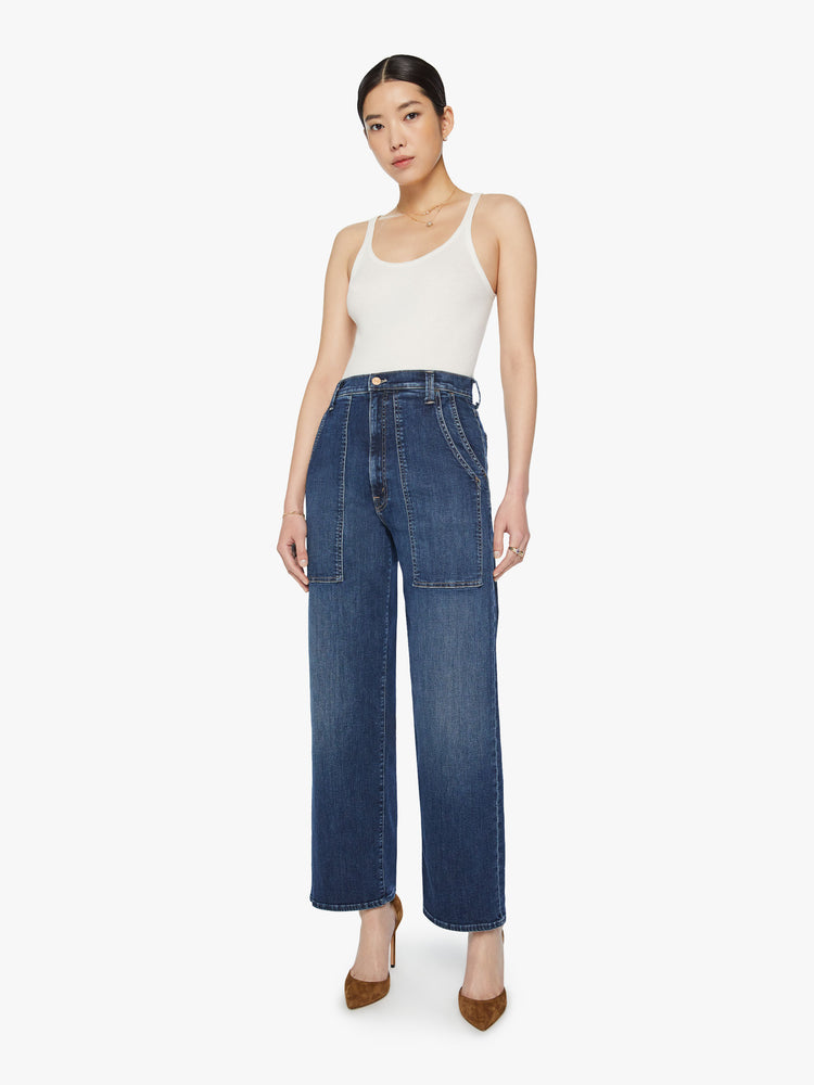 Front view of a woman wide straight-leg jeans with a super high rise, oversized double patch pockets and a clean hem in a dark blue wash.