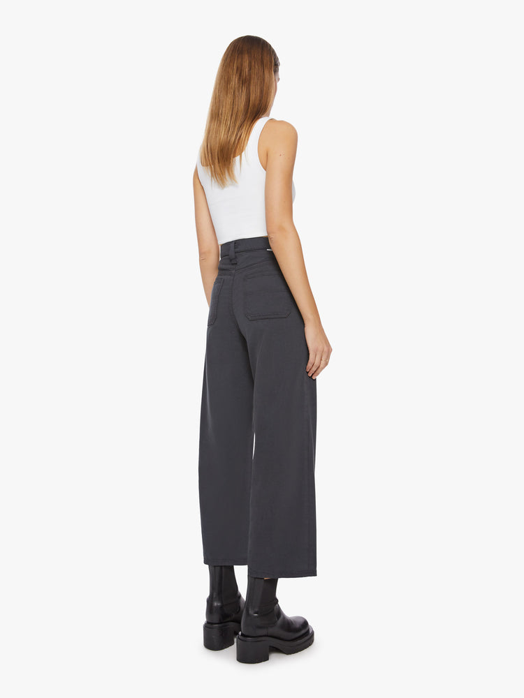 Back view of a woman faded black super high-waisted pants with deep, double patch pockets, a wide straight leg and a cropped hem.