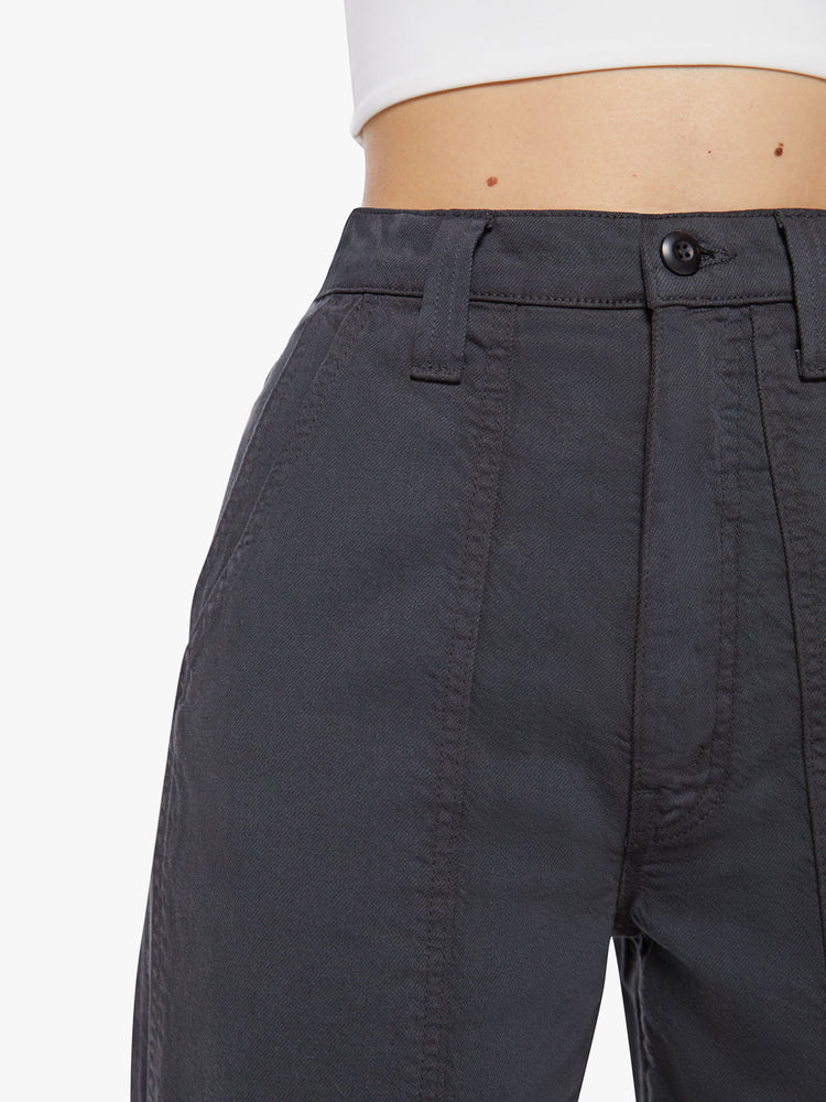 Waist close up view of a woman faded black super high-waisted pants with deep, double patch pockets, a wide straight leg and a cropped hem.