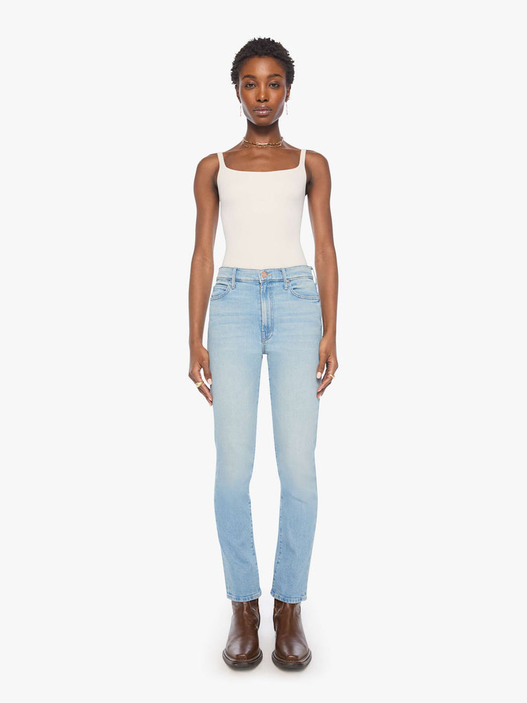 Front view of a woman in a light buw high-rise straight-leg jean with a zip fly, 29-inch inseam and a clean hem.